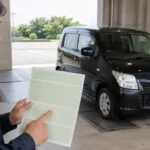 車検証で型式を確認する日本人男性と黒いワゴンR
