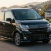朝の坂道を左側通行で走る黒いワゴンRスティングレー中古車のイメージ